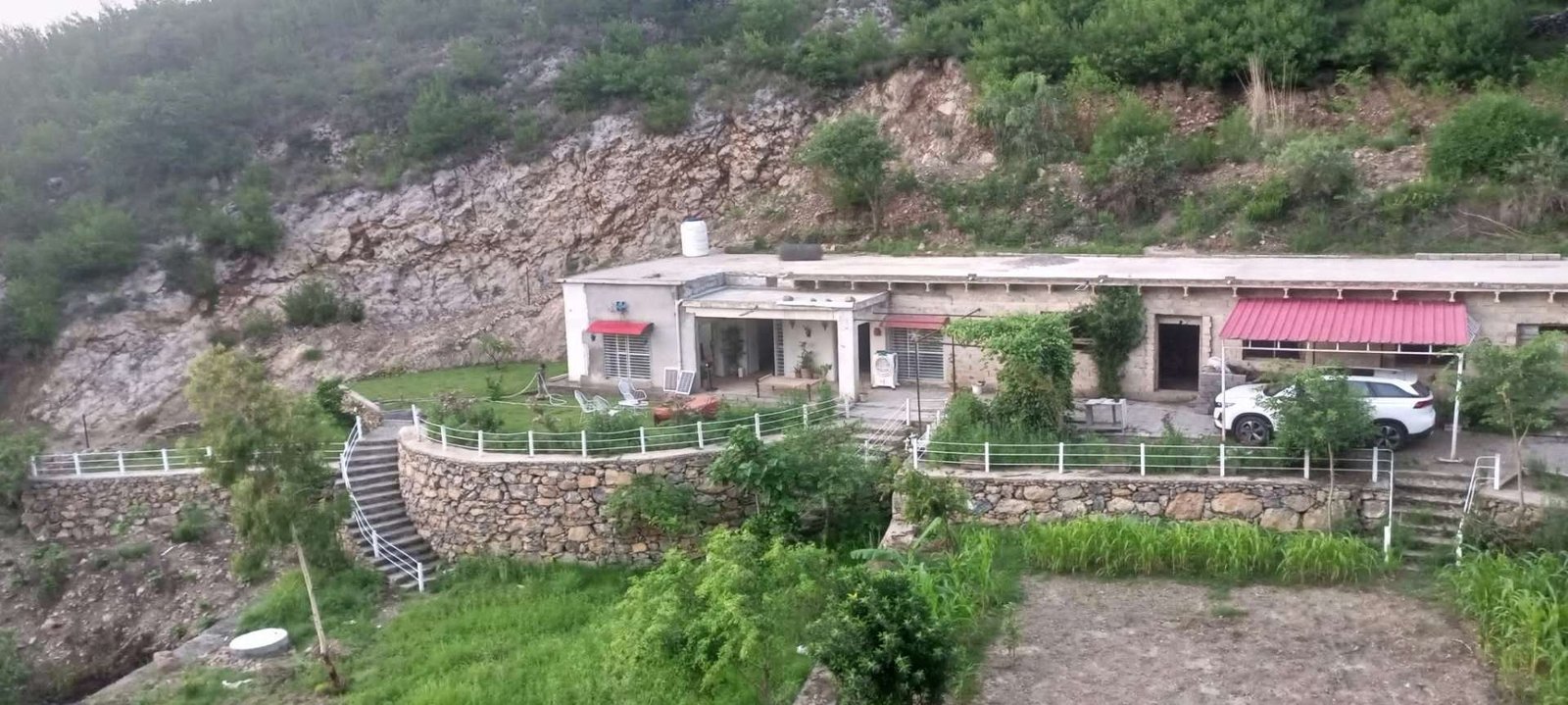 YULSA Farm House stone terrace with mountain backdrop in Khanpur