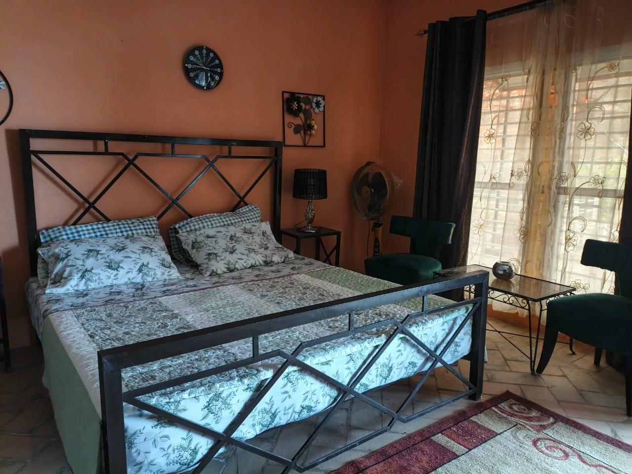 Warm-toned bedroom with a wrought-iron bed and floral linens